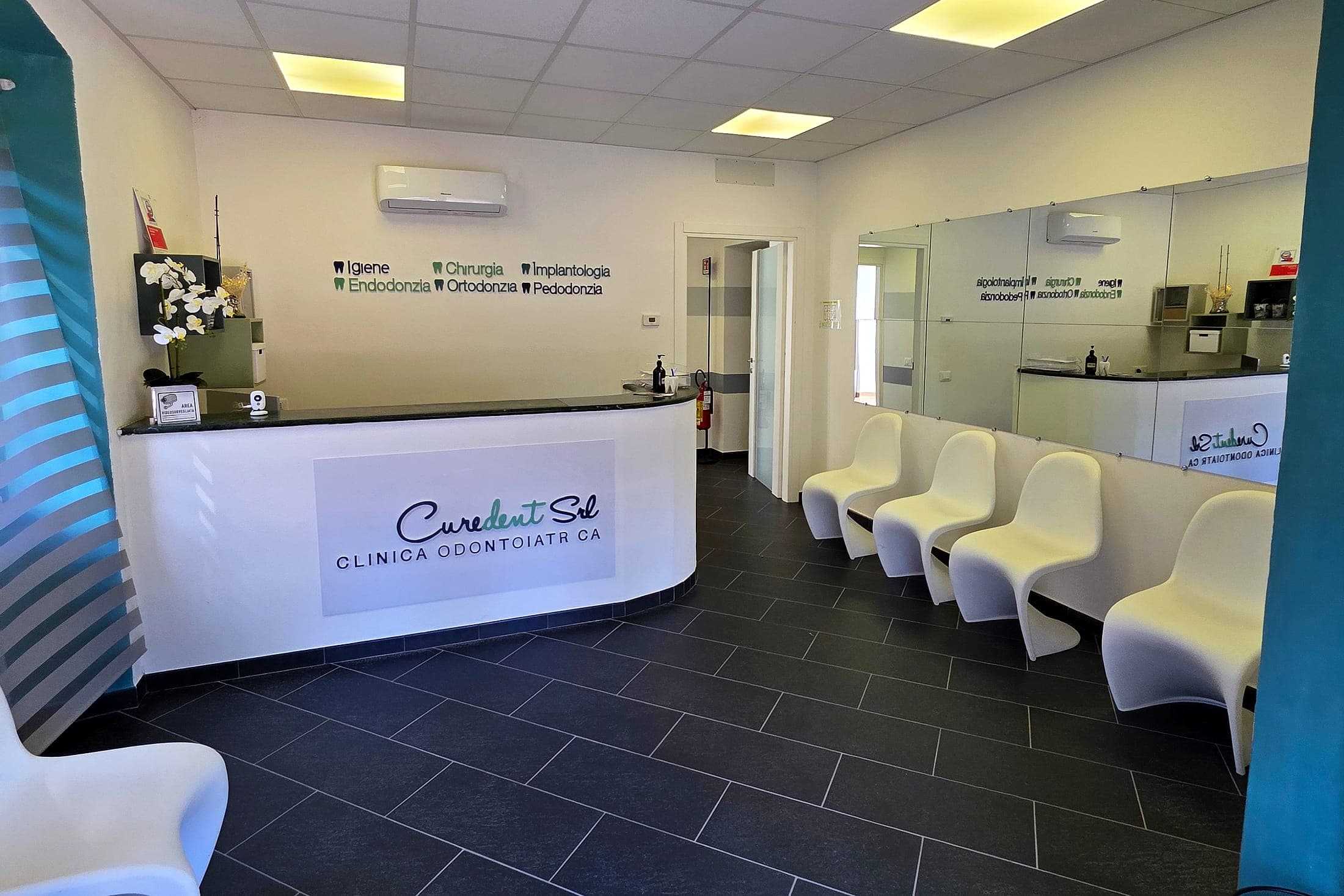 L'accoglienza di Curedent, con il bancone e le sedute bianche