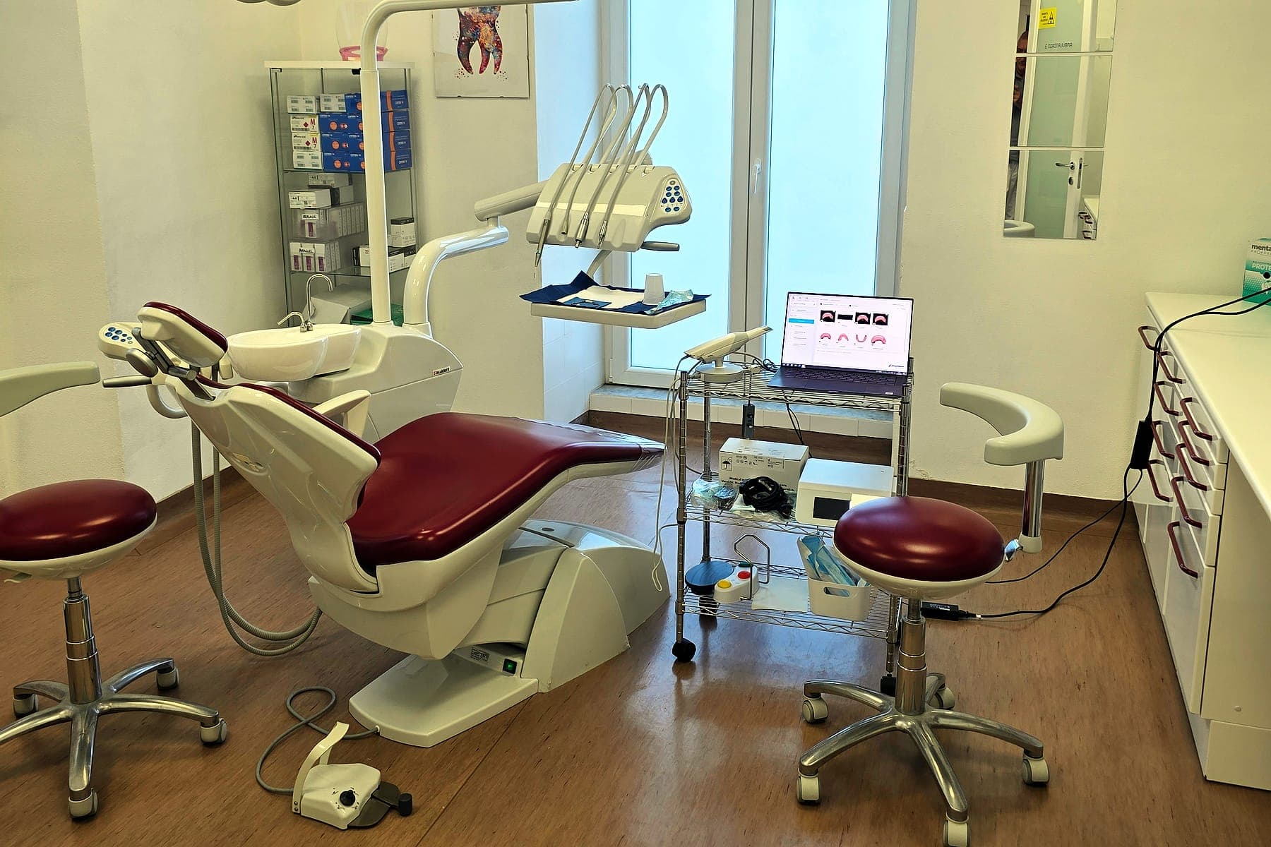 La sala bordeaux con lo scanner intraorale sul carrello accanto alla poltrona